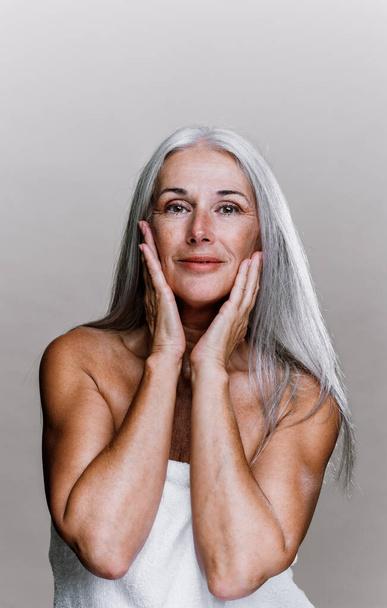 Image of a beautiful senior woman posing on a beauty photo session. Middle aged woman on a colored background. Concept about body positivity, self esteem and body acceptance - Fotografie, Obrázek