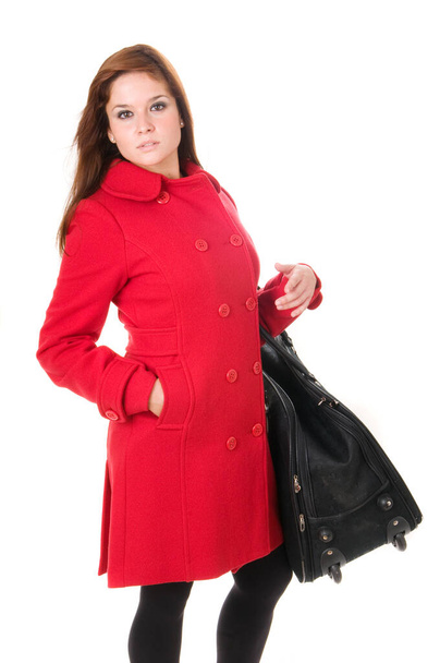 Attractive woman in red coat with bag or suitcase on white background - Valokuva, kuva