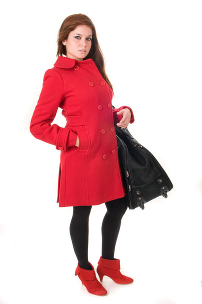 Attractive woman in red coat with bag or suitcase on white background - Фото, зображення