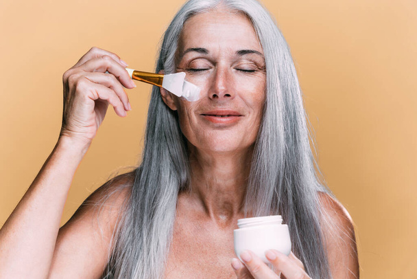 Image of a beautiful senior woman posing on a beauty photo session. Middle aged woman on a colored background. Concept about body positivity, self esteem and body acceptance - Foto, afbeelding