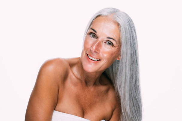 Image of a beautiful senior woman posing on a beauty photo session. Middle aged woman on a colored background. Concept about body positivity, self esteem and body acceptance - Photo, Image