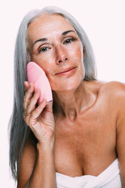 Image of a beautiful senior woman posing on a beauty photo session. Middle aged woman on a colored background. Concept about body positivity, self esteem and body acceptance - Foto, Imagem