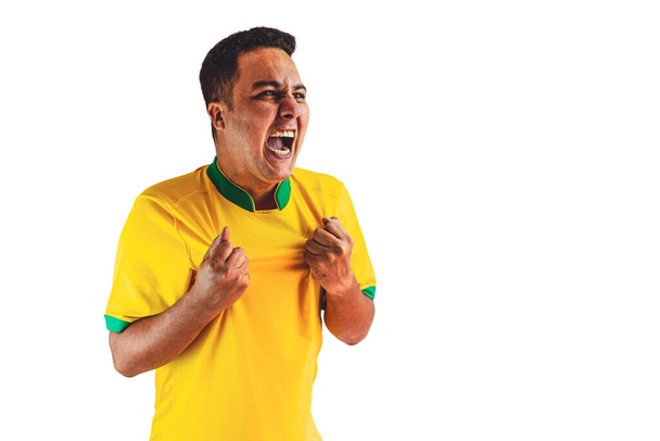 Jugador de fútbol brasileño celebrando en un fondo blanco. Retrato dramático de un jugador de fútbol negro con bandera. - Foto, imagen