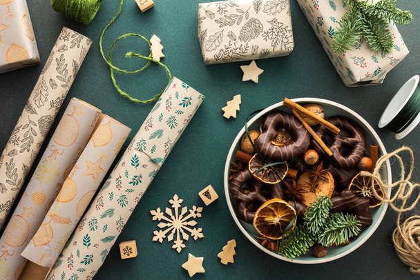 Preparazione per la festa, confezionamento di regali sotto l'albero di Natale in carta artigianale, Buon Natale e Capodanno concetto, piatto con biscotti e fette di mandarino secco - Foto, immagini