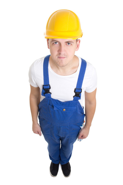 полный портрет молодого красивого строителя человека в синем unifo - Фото, изображение