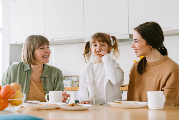 White family laughing and having breakfast while spending time together at home - Zdjęcie, obraz