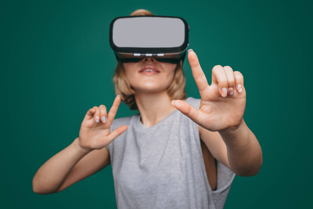 Kaukasische Frau im VR-Headset erkundet neue Welten im Videospiel isoliert vor grünem Hintergrund. Futuristischer Lebensstil. Zukünftige Computertechnologie. Moderne - Foto, Bild