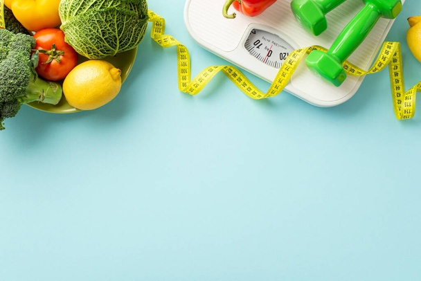 Slimming concept. Top view photo of plate with vegetables cabbage lemons cauliflower tomato dumbbells scales and tape measure on isolated pastel blue background with copyspace - Photo, Image