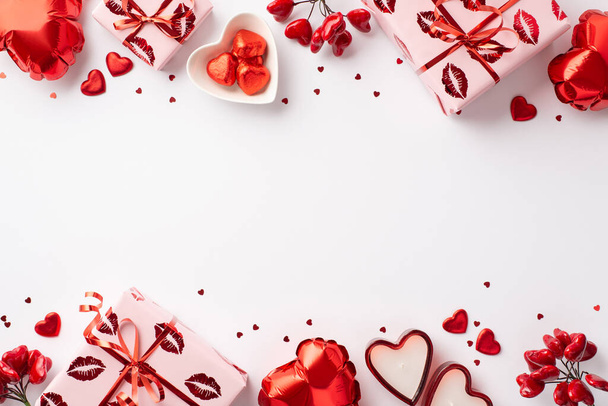 Concepto del Día de San Valentín. Foto vista superior de cajas de regalo en papel de regalo con labios de beso patrón en forma de corazón globos velas platos con caramelos confeti sobre fondo blanco aislado con copyspace - Foto, imagen