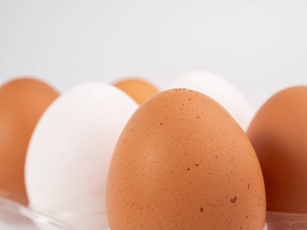 Chicken eggs on a white background. White and brown egg on a white background. Close-up. - 写真・画像