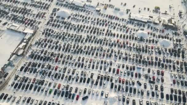 Widok z powietrza na wiele samochodów zaparkowanych na sprzedaż i ludzi klientów spacerujących po rynku samochodowym lub parkingu w zimie. - Materiał filmowy, wideo