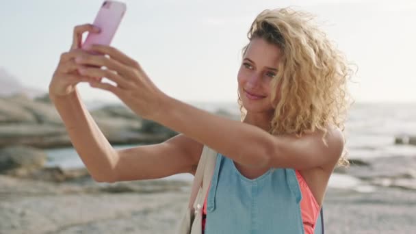 Selfie, smartphone and woman at the beach for social media post, networking on mobile app or location update in her travel blog. Young, happy gen z influencer girl in cellphone photography by the sea. - Video