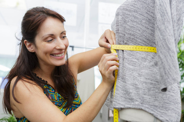close up of a seamstress measuring mannequin waist - Fotografie, Obrázek
