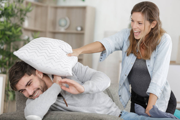 happy couple doing a funny pillow fight - Фото, зображення