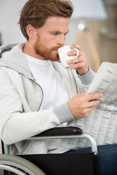 happy man at home drinking coffee and reading newspaper - Foto, Imagem