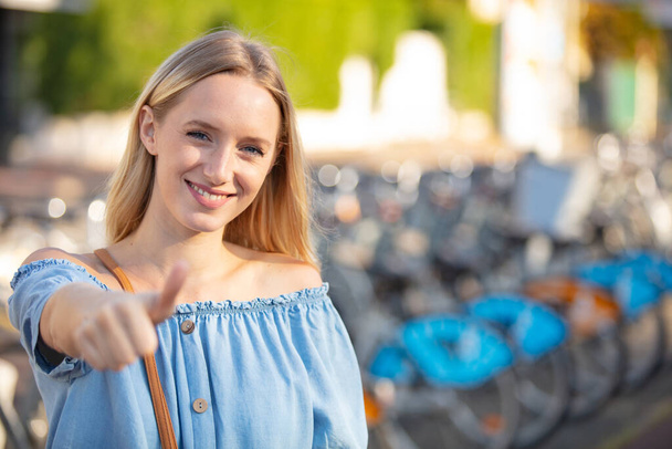 young woman gives thumb up outdoor - Photo, image