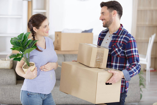 pregnant couple moving in a new house - Foto, afbeelding
