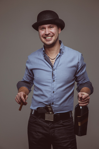 Man with pistol smiles with alcohol and cigar - Fotoğraf, Görsel