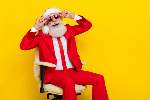 Photo of positive successful man sit chair arms touch glasses have good mood isolated on yellow color background. - 写真・画像