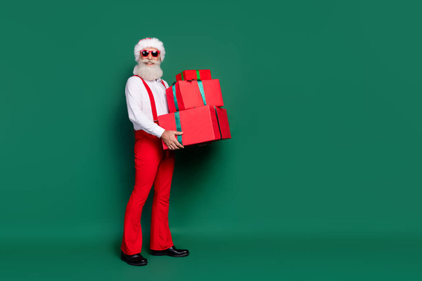Full length photo of pretty cute man dressed xmas costume delivering gifts stack empty space isolated green color background. - Fotoğraf, Görsel