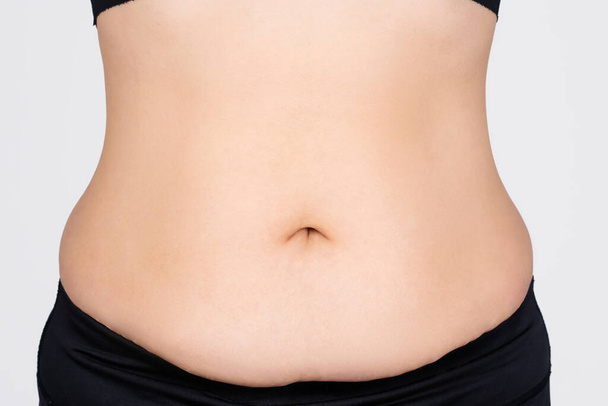 Ázsiai kövér nő túlsúlyos Azt mutatja, felesleges hasi zsír, álló elszigetelt fehér háttér. Szépségkoncepció. - Fotó, kép