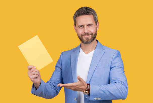 studio shot of businessman holding planner. photo of businessman hold planner. businessman with planner isolated on yellow background. businessman with planner in jacket. - 写真・画像
