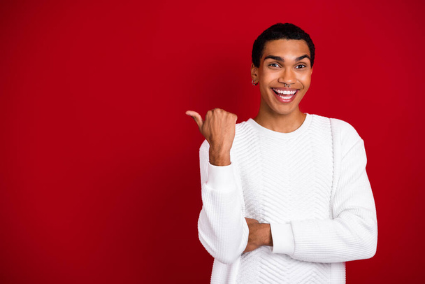 Photo of youngster funky man wear white pullover laughing enjoy xmas information finger point empty space new advert isolated on red color background. - Foto, Bild