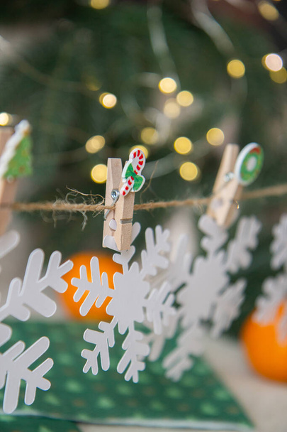 Christmas garland of snowflakes on wooden clothespins - Foto, afbeelding