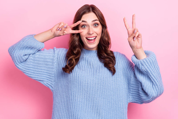 Portrait of overjoyed cheerful lady toothy smile hands fingers show v-sign near eye isolated on pink color background. - Photo, image