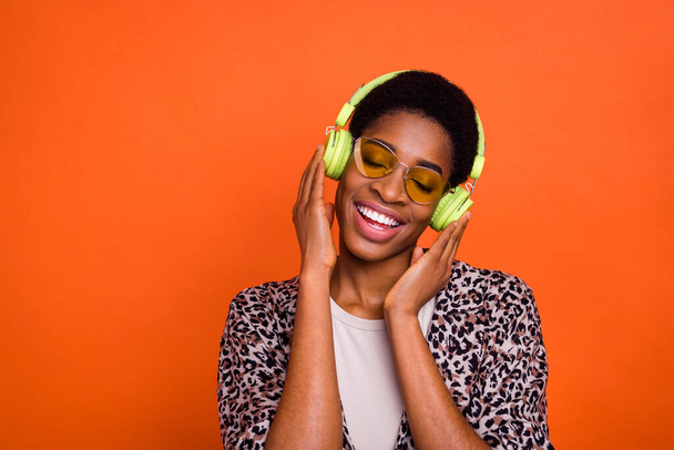 Portrait of attractive dreamy cheerful trendy carefree girl listening hit pop isolated over vivid orange color background. - Φωτογραφία, εικόνα