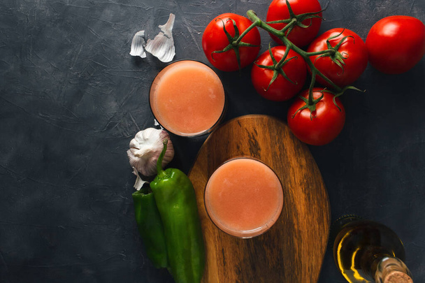 新鮮なトマト、ピーマン、ニンニク、オリーブオイルと典型的なスペインのトマトスープ(アンダルシアガスパチョ)のトップビュー。コピースペース付きおいしいガスパチョのガラス. - 写真・画像