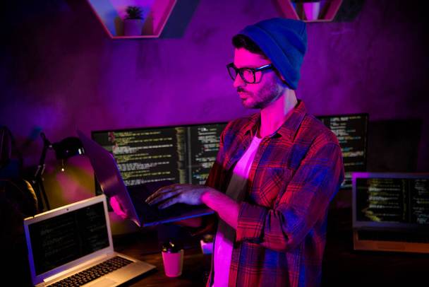 Photo of ponder pensive guy dressed glasses hat writing safety code modern device indoors workstation workshop home. - Foto, Bild