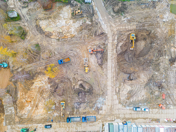 İnşaatta çalışan kazıcı ve buldozerlerin havadan çekilmiş fotoğrafı. - Fotoğraf, Görsel