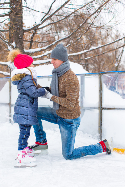 Familia feliz en pista de patinaje al aire libre
 - Foto, Imagen