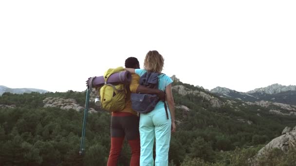 Multiraciaal koppel trekking op de top van de berg, achteraanzicht, reizen backpackers, digitale nomaden. - Video