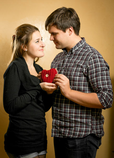 smiling couple in love holding red heart in hands - Photo, Image