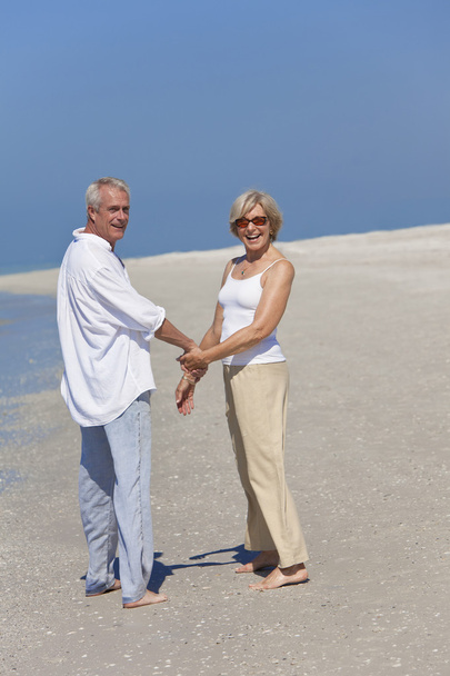 Happy Senior Couple Walking Holding Hands on Beach - Photo, Image