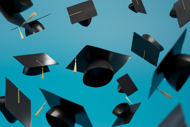 abstract background consisting of master's caps flying over the blue background. 3D render. - Photo, Image