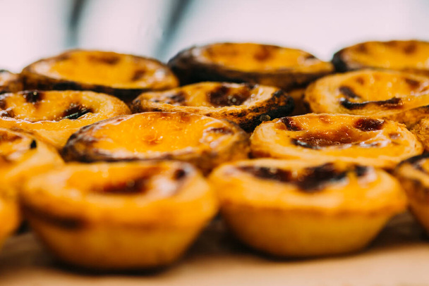Stack of Portuguese egg tart also known as Pasteis de Nata on display in front of shop - selective focus - Photo, Image
