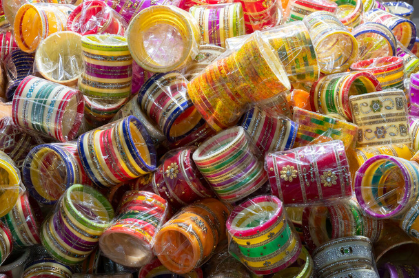 Jasné barevné Rajasthani náramky se prodávají na slavném sardarském trhu a Ghanta ghar Hodiny věž v Jodhpur, Rajasthan, Indie. - Fotografie, Obrázek