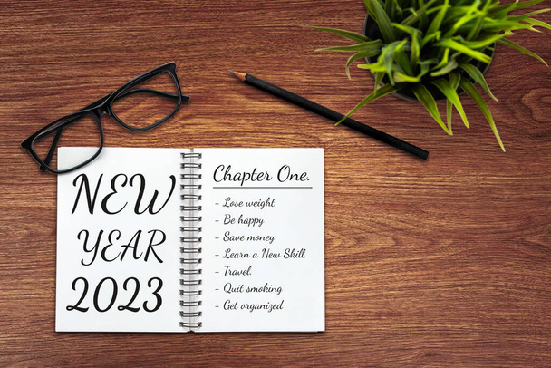 2023 Lista de objetivos y establecimiento de planes de feliz año nuevo - Escritorio de oficina de negocios con cuaderno escrito sobre la lista de planes de metas de año nuevo y el establecimiento de resoluciones. Cambio y concepto de determinación. - Foto, imagen