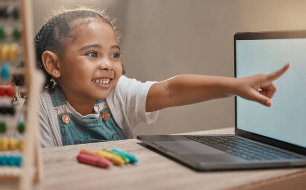 Bildung, Schule und Grundschulbildung mit einem Mädchen, das auf einen Laptop zeigt, während es für Entwicklung studiert. Computer, Mathe und Internet mit einer Schülerin, die allein in ihrem Haus lernt. - Foto, Bild