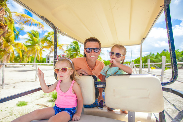 Papa und seine kleinen Mädchen fahren Golfcart am tropischen Strand - Foto, Bild