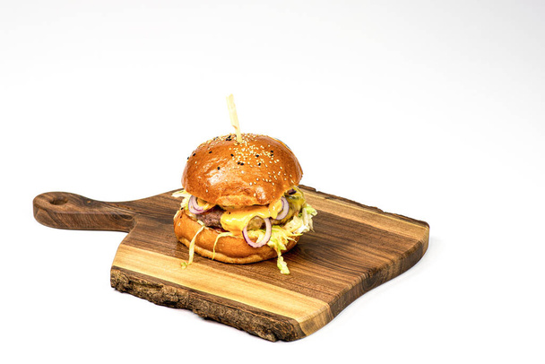 Świeży hamburger domowej roboty na drewnianej desce. Białe tło z miejscem do kopiowania. - Zdjęcie, obraz