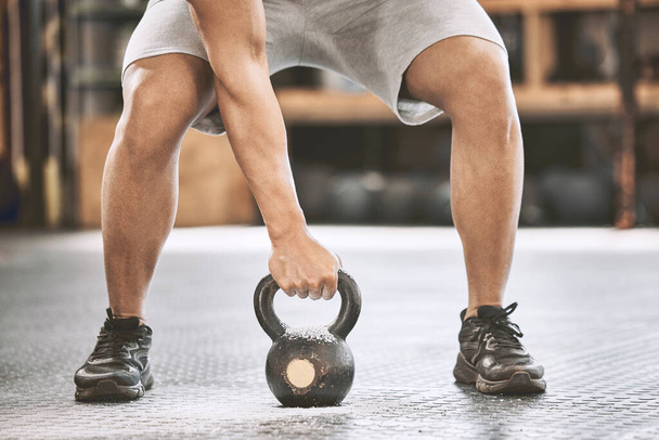 Fit athlete lifting a heavy kettlebell. Strong bodybuilder doing an arm exercise. Bodybuilder lifting weights in the gym cropped. Bodybuilding endurance strength training builds strong muscle. - Photo, image