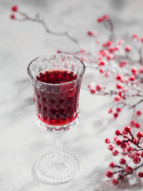 Egy pohár cseresznye likőr vagy bor fehér alapon. Karácsonyi vagy újévi party ünnepség koncepció. Téli ünnepek fogalma. - Fotó, kép