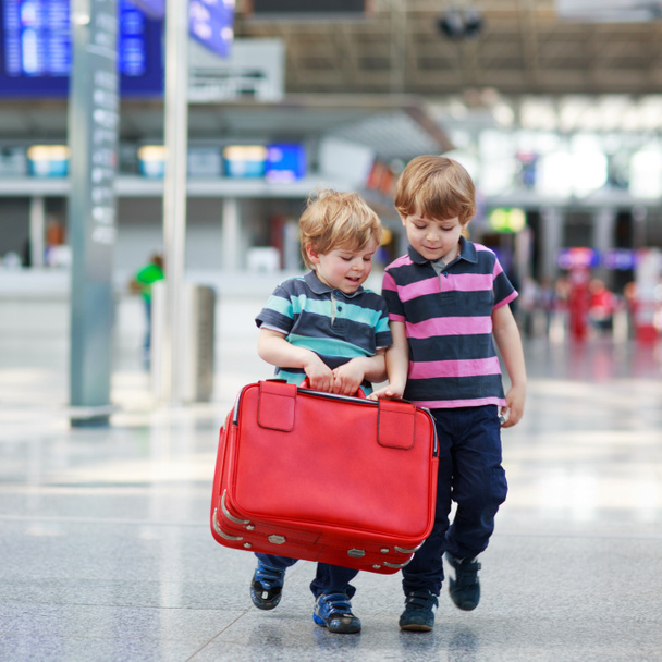 Two brother boys going on vacations trip at airport - Zdjęcie, obraz
