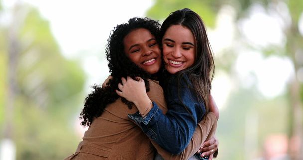 Dos amigas abrazándose, concepto de diversidad, dos chicas diversas abrazándose fuera - Foto, imagen