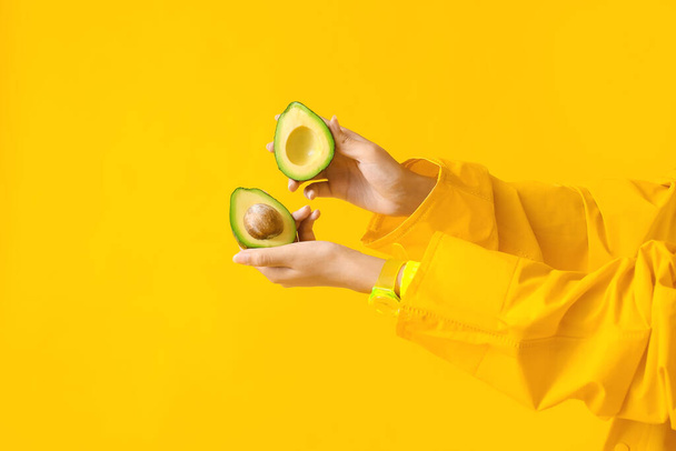 Female hands with avocado on color background - Photo, Image