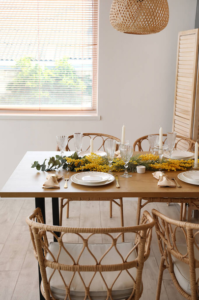 Schöne Tischdekoration mit Mimosen Blumen und Kerzen im Zimmer - Foto, Bild